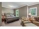 Comfortable bedroom features a queen bed, chair and ottoman seating area, and beautiful natural light at 155 Palmer Oaks Ln, Marietta, GA 30068