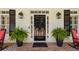 Elegant black front door framed by sidelights, decorative lanterns, and lush potted ferns on a brick porch at 155 Palmer Oaks Ln, Marietta, GA 30068