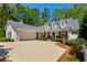 Charming white home with a spacious driveway and a well-manicured front yard featuring lush greenery and colorful flowers at 155 Palmer Oaks Ln, Marietta, GA 30068
