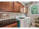 Bright laundry room with wood cabinets, front load washer and dryer and lots of natural light from window at 155 Palmer Oaks Ln, Marietta, GA 30068