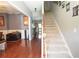 Inviting foyer featuring hardwood floors, staircase with carpet runner, and views into the adjacent living areas at 309 Daffodil Dr, Temple, GA 30179