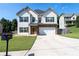 Charming two-story home featuring a well-maintained front yard, driveway, and inviting front door with stone accents at 309 Daffodil Dr, Temple, GA 30179