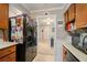 Kitchen view into a living area with a black refrigerator, wood cabinets and white countertops at 3105 Colonial Way # F, Atlanta, GA 30341