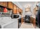 Compact kitchen with wood cabinets, black appliances and laundry area featuring a washing machine at 3105 Colonial Way # F, Atlanta, GA 30341