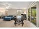 Bright living room with a large table, sliding glass doors to the balcony, and a comfortable blue sofa at 3105 Colonial Way # F, Atlanta, GA 30341
