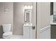 Bright half bathroom boasts a white vanity, a mirror, and a decorative wall hanging at 5663 Brookstone Nw Dr, Acworth, GA 30101