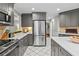 Contemporary kitchen featuring stainless steel appliances, sleek gray cabinets, and bright white tiled flooring at 5663 Brookstone Nw Dr, Acworth, GA 30101
