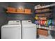 Laundry room offers modern washer and dryer, dark walls, and ample storage shelving at 5663 Brookstone Nw Dr, Acworth, GA 30101