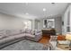 Comfortable living room features a gray sectional sofa, hardwood floors, and view into the kitchen at 5663 Brookstone Nw Dr, Acworth, GA 30101