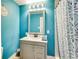Fresh bathroom features a white single sink vanity, brushed silver faucet, and a blue shower curtain at 150 Burke St Ne, Marietta, GA 30060