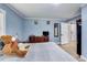 Bedroom featuring blue walls, wood floors, a dresser with a television, and barn door access to the bathroom at 150 Burke St Ne, Marietta, GA 30060