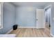 Bedroom featuring pale blue walls, light wood flooring, and doorway access to another room at 150 Burke St Ne, Marietta, GA 30060
