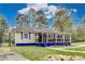 Charming single-story home with a welcoming front porch and blue accents, nestled among mature trees at 150 Burke St Ne, Marietta, GA 30060