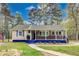 Charming single-story home with a welcoming front porch and blue accents, nestled among mature trees at 150 Burke St Ne, Marietta, GA 30060