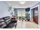 Bright living room featuring light hardwood floors, leafy plants, a dark leather couch, and an adjacent office area at 150 Burke St Ne, Marietta, GA 30060