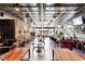 Open restaurant interior featuring a long bar, exposed brick, modern tables, and tin-style ceiling at 1968 8Th St, Chamblee, GA 30341