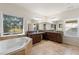 Bright bathroom with a large window, separate vanities, and soaking tub at 3597 Old Maple Rd, Johns Creek, GA 30022