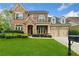 Charming two-story brick home featuring a well-manicured lawn and attached two car garage at 3597 Old Maple Rd, Johns Creek, GA 30022