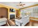 Comfortable living room featuring a fireplace, ceiling fan and lots of natural light at 3597 Old Maple Rd, Johns Creek, GA 30022