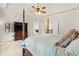 Comfortable main bedroom featuring a ceiling fan, neutral carpet, and a television cabinet at 3597 Old Maple Rd, Johns Creek, GA 30022