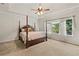 Spacious main bedroom featuring a four-poster bed, tray ceiling and large windows for natural light at 3597 Old Maple Rd, Johns Creek, GA 30022
