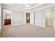 Spacious bedroom with tray ceiling, carpeted flooring and three doors for closet, bathroom and hall access at 4899 Seldon Se Way, Smyrna, GA 30080