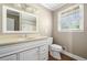 Well-lit bathroom featuring a vanity, toilet, and a shower with a large mirror above the sink at 1061 Pathfinder Rd, Marietta, GA 30066