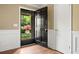 Inviting entryway with a stylish black door and hardwood floors, offering a glimpse of the landscaped yard at 1061 Pathfinder Rd, Marietta, GA 30066