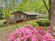Inviting brick home featuring lush landscaping with colorful flowers and mature trees in a serene setting at 1061 Pathfinder Rd, Marietta, GA 30066