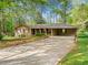 Charming single-story brick home with a long driveway, carport, and beautifully landscaped front yard at 1061 Pathfinder Rd, Marietta, GA 30066