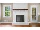 Living room featuring a white brick fireplace, hardwood floors, and a bright window at 1061 Pathfinder Rd, Marietta, GA 30066