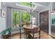 Sunlit breakfast nook featuring a round table, chairs, and large windows overlooking a green backyard at 1180 Brookhaven Park Ne Pl, Brookhaven, GA 30319