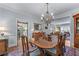 Formal dining room boasts a stylish chandelier, wood floors and views to the kitchen and living room at 1180 Brookhaven Park Ne Pl, Brookhaven, GA 30319