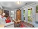 Cozy living room leading to french doors, filled with a comfortable sofa, natural light, and hardwood floors at 1180 Brookhaven Park Ne Pl, Brookhaven, GA 30319