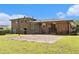 Expansive backyard with a brick house, patio, and lush green lawn under a sunny sky at 2044 Yucca Dr, Decatur, GA 30032