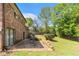 Spacious backyard with a brick patio, lush greenery, and mature trees at 2044 Yucca Dr, Decatur, GA 30032