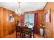 Charming dining room showcasing wood paneling, hardwood floors, elegant chandelier, and natural light at 2044 Yucca Dr, Decatur, GA 30032