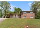 Two-story brick home with a covered carport and quaint front porch, set on a lovely green lawn at 2044 Yucca Dr, Decatur, GA 30032