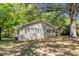 Well-manicured yard of brick house with white trim and shutters under a canopy of trees at 2925 Heather Dr, Atlanta, GA 30344