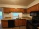 Cozy kitchen with granite countertops, wooden cabinets, and black appliances at 323 Seasons Pkwy, Norcross, GA 30093