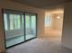 Living room with sliding glass door to enclosed patio and dining room to the right with chandelier at 323 Seasons Pkwy, Norcross, GA 30093