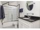 Bathroom featuring a tub with glass doors, black and white tile floor, and granite countertop sink at 334 Sutherland Ne Pl, Atlanta, GA 30307