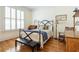 Cozy bedroom with hardwood floors, iron bed frame, and large window with shutter at 334 Sutherland Ne Pl, Atlanta, GA 30307