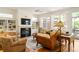 Cozy living room with a fireplace, custom built-ins, and large windows offering scenic outdoor views at 334 Sutherland Ne Pl, Atlanta, GA 30307