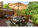 Inviting outdoor dining area with a table, umbrella, chairs, and a bench surrounded by lush greenery at 334 Sutherland Ne Pl, Atlanta, GA 30307