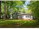 Backyard with green grass and the home's exterior, surrounded by mature trees at 1002 Forrest Blvd, Decatur, GA 30030
