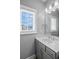 Bathroom featuring a single sink vanity, white countertop and large sun-filled window at 3024 Eamont Ter, Atlanta, GA 30328