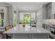 Bright kitchen features gray cabinets, quartz island with sink and seating, and stainless appliances and breakfast bar at 3024 Eamont Ter, Atlanta, GA 30328