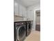 Modern laundry room with front loading machines, stylish cabinets and granite countertop at 3024 Eamont Ter, Atlanta, GA 30328