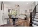 Open-concept living space with fireplace, hardwood floors, large windows, and a staircase leading to the upper level at 3024 Eamont Ter, Atlanta, GA 30328